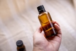 a person holding a bottle of essential oils