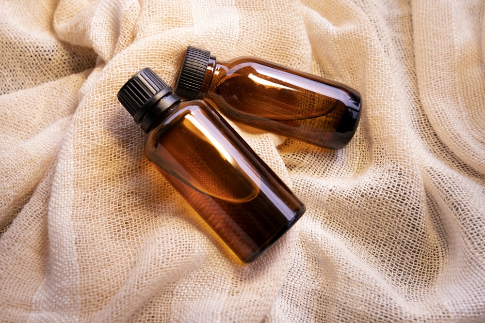 a couple of brown bottles sitting on top of a bed