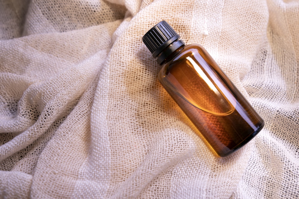 a bottle of perfume sitting on top of a white cloth