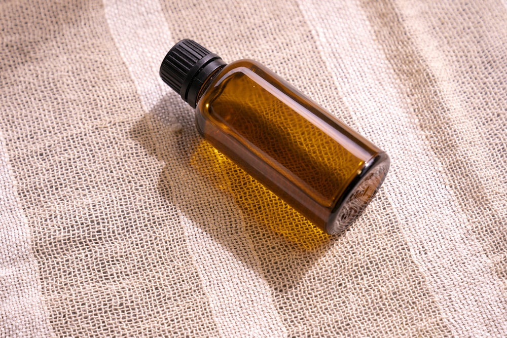 a bottle of essential oil sitting on a cloth