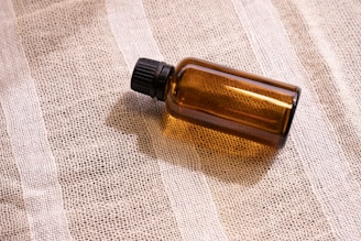 a bottle of essential oil sitting on a cloth
