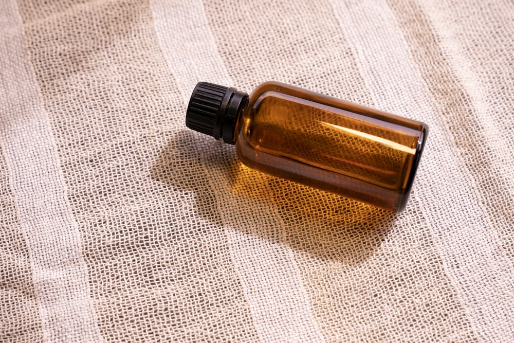 a bottle of essential oil sitting on a cloth
