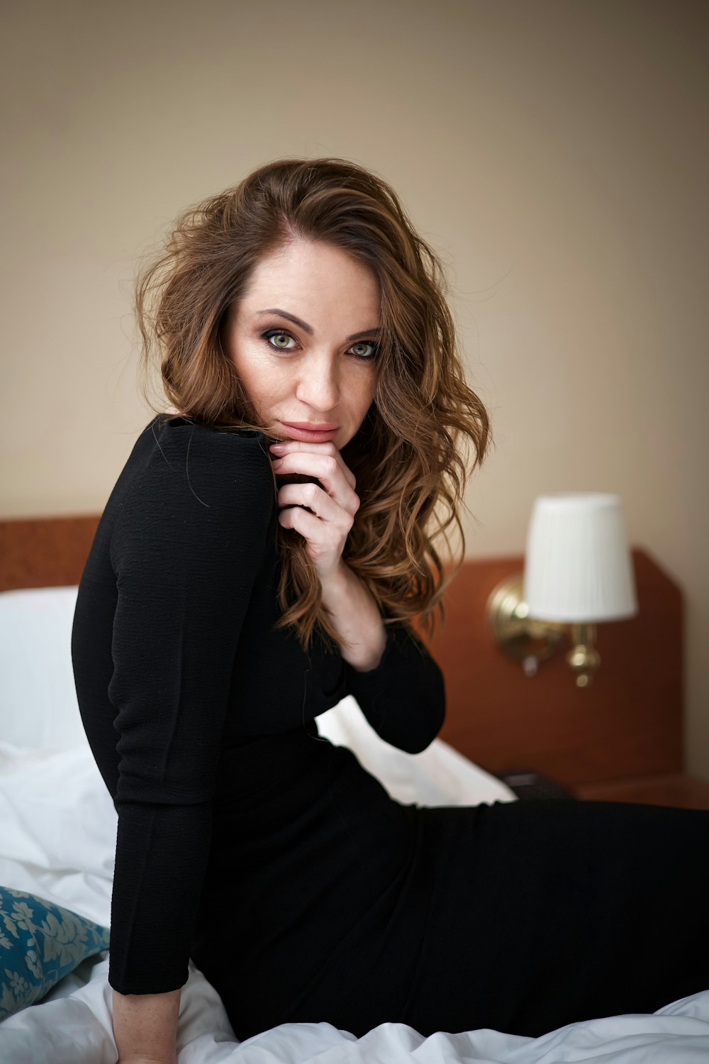 a woman sitting on a bed posing for a picture