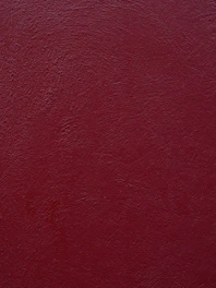 a close up of a red wall with a white clock on it