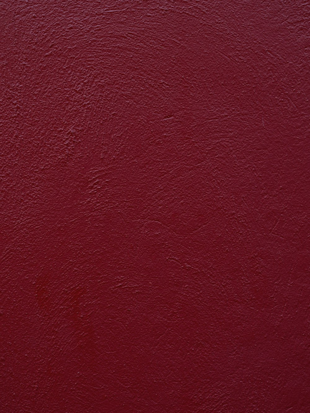 a close up of a red wall with a white clock on it