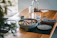 A warm, inviting dining table set with a shiny brass serving bowl filled with fresh salad.
