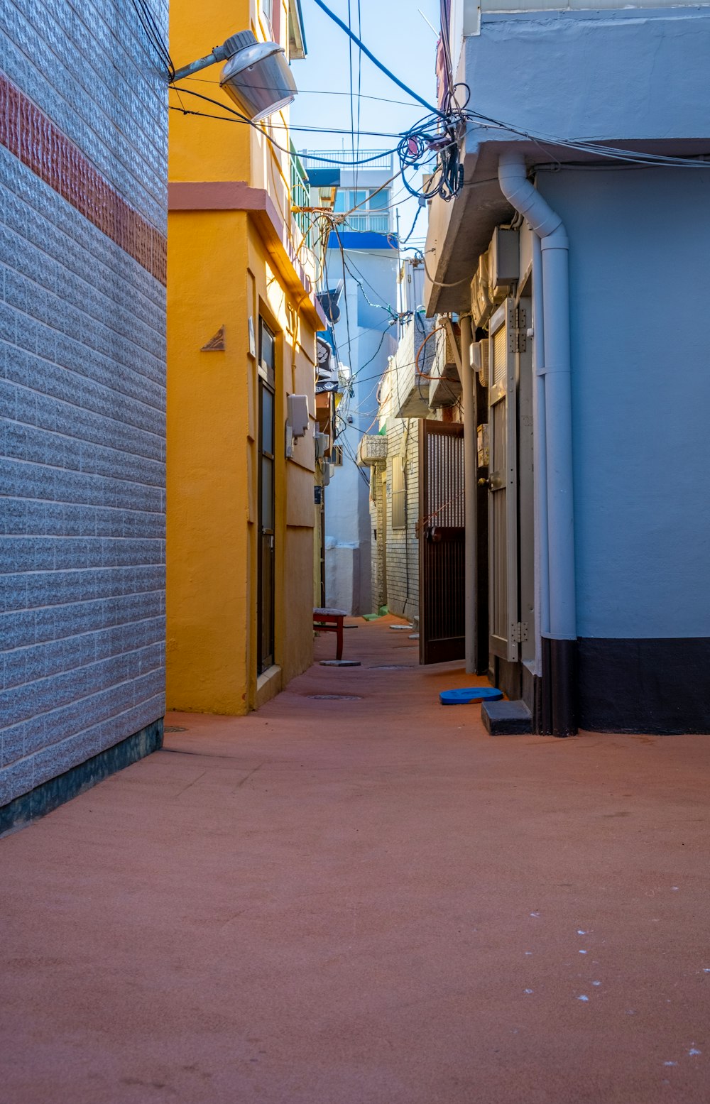 a narrow city street with a yellow building