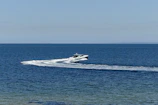 Premium speedboat cutting through the waves under a clear blue sky.