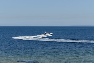 Speedboat cruising near Maldivian islands under a bright blue sky.