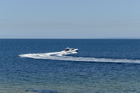 Speedboat cruising near Maldivian islands under a bright blue sky.