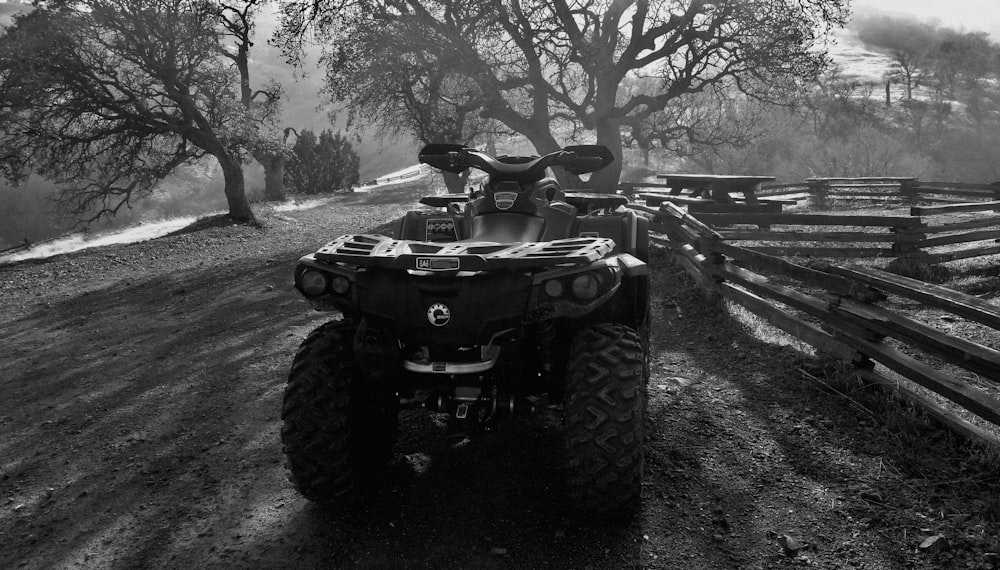 a black and white photo of a four - wheeler on a dirt road