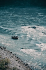 A group of friends rafting energetically down a lively river surrounded by lush greenery.
