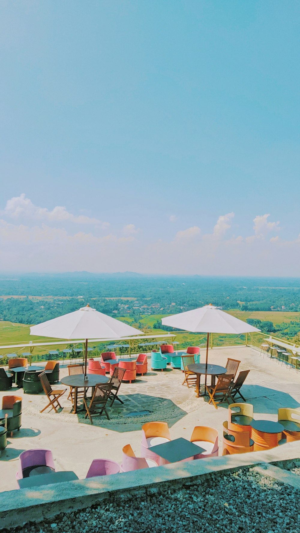 a group of chairs and umbrellas sitting on top of a hill