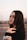 a woman with long brown hair and a black shirt