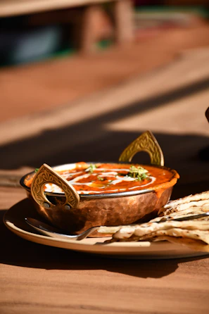 Golden prawn curry served in a traditional bowl with naan bread on the side.