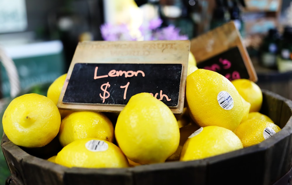 a basket of lemons for sale at a market