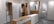 A showroom displaying modern, minimalist wardrobes and dressers with a light wood and white color scheme. The space is organized, showing various styles of wardrobes with sliding and hinged doors, some with mirrors. Tags with product information are visible, suggesting a retail setting.