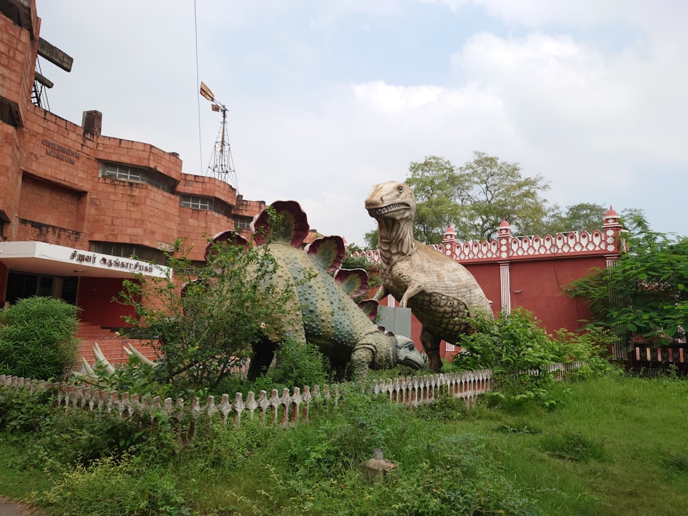 a statue of a dinosaur in front of a building