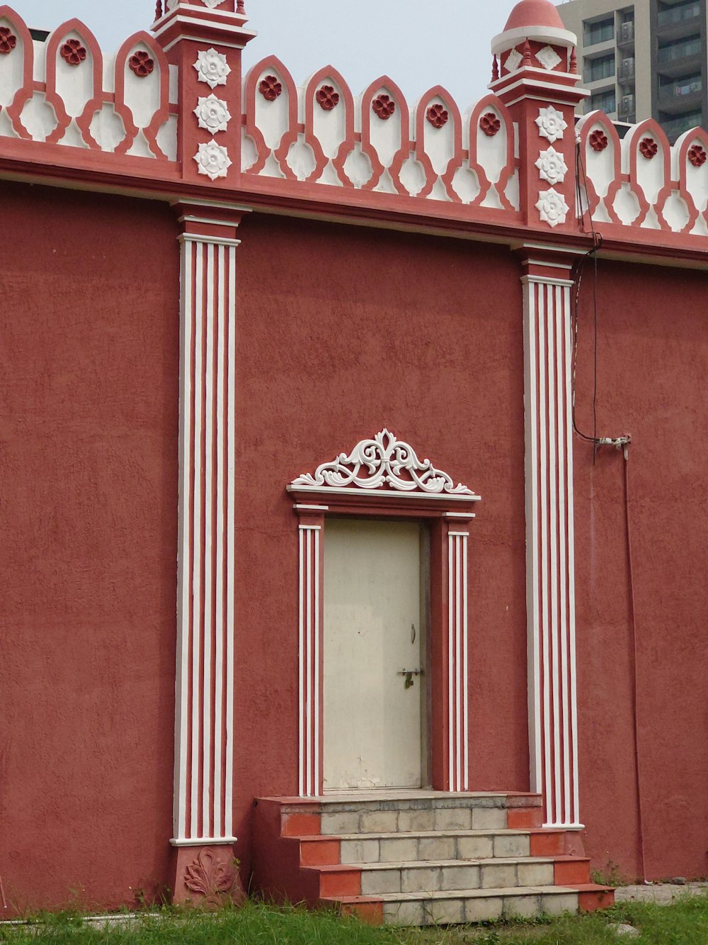 a red building with columns and a door