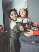 Happy pets wearing matching outfits playing together in a bright room