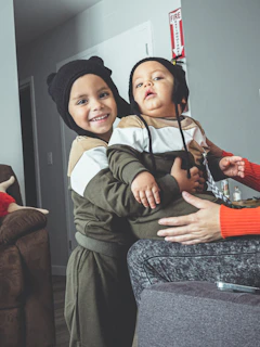 A happy dog and cat sitting side by side, both dressed in matching handmade outfits with cheerful patterns