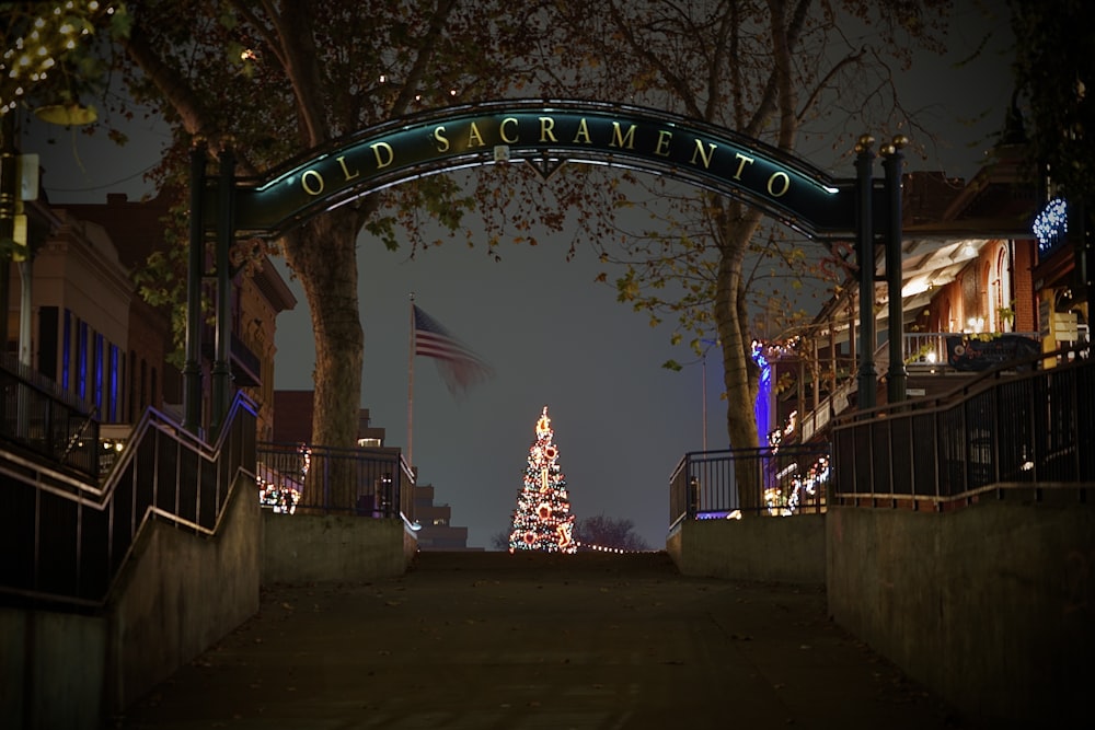 a lighted christmas tree in front of a gate