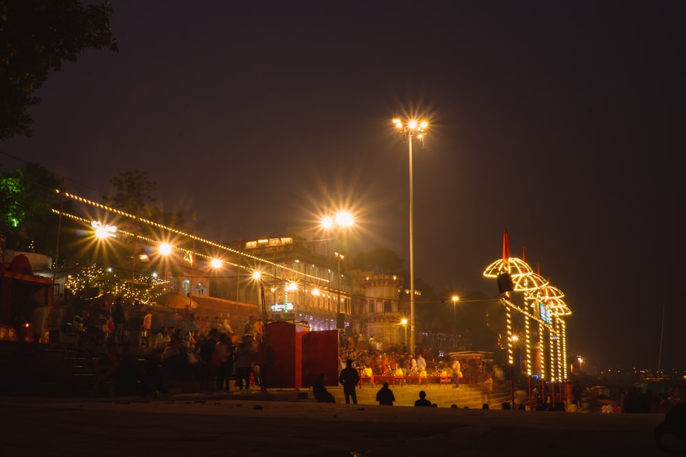 a group of people standing around a street at night