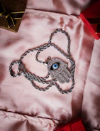 A sparkling silver necklace laid out on soft fabric.