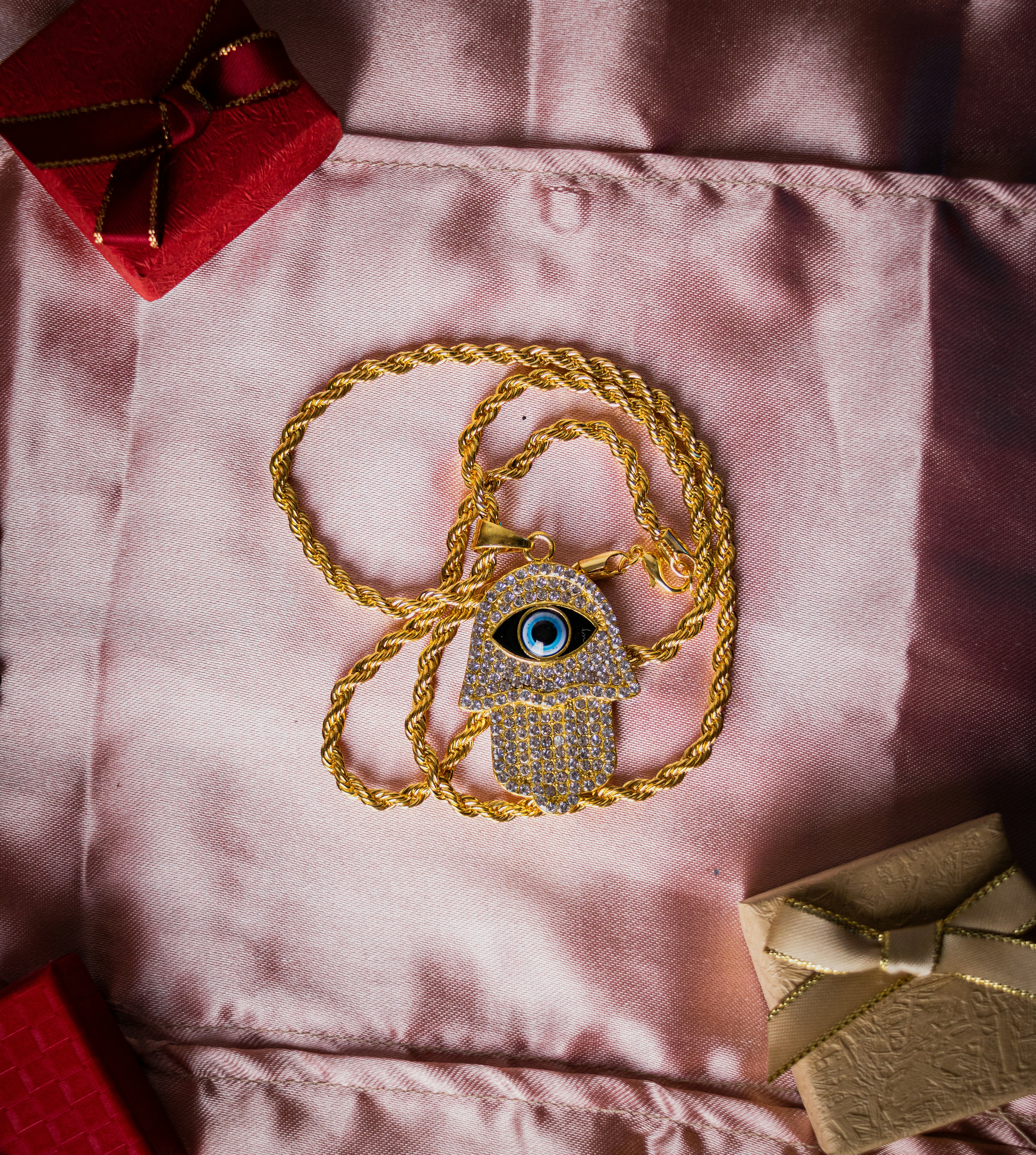 a gold necklace with a hamsa hanging from it