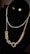 A display of a gold necklace with a layered chain and star-shaped earrings is elegantly arranged on a black velvet stand. The necklace features a combination of thin and chunky links, creating a stylish contrast.