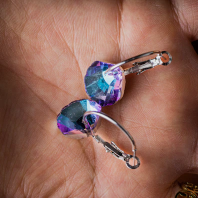 Pair of handcrafted earrings with colorful gemstones sparkling in natural light.