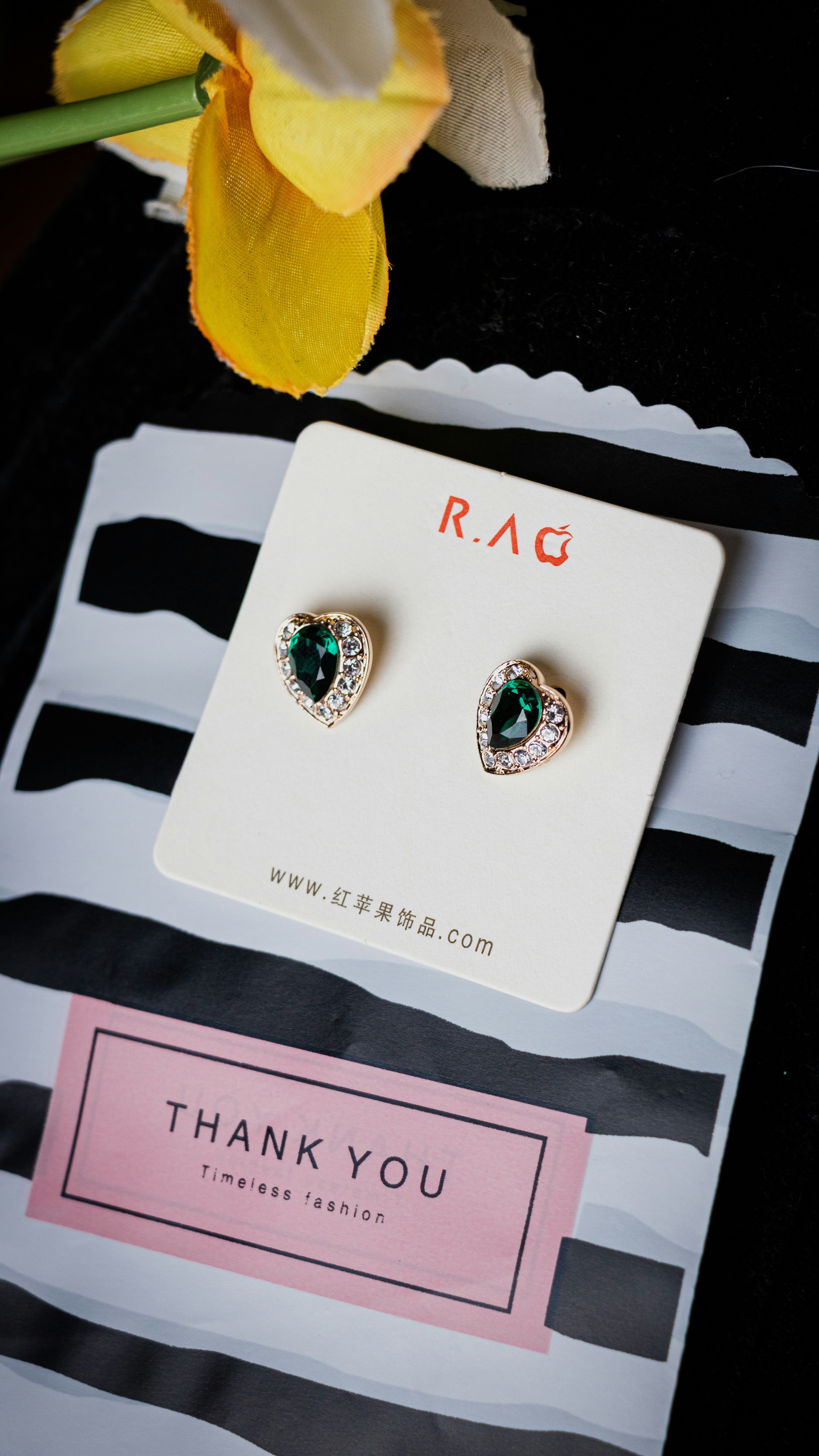 Kundan stud earrings with gold setting and green stone centre on white background