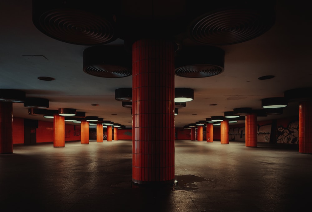 an empty room with red columns and lights