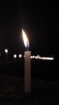A serene close-up of a lit candle with soft shadows, evoking calm and remembrance.