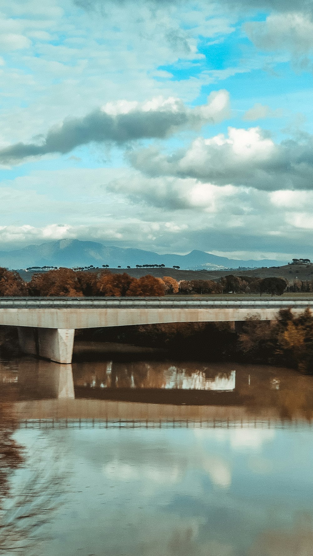 a bridge over a body of water under a cloudy sky