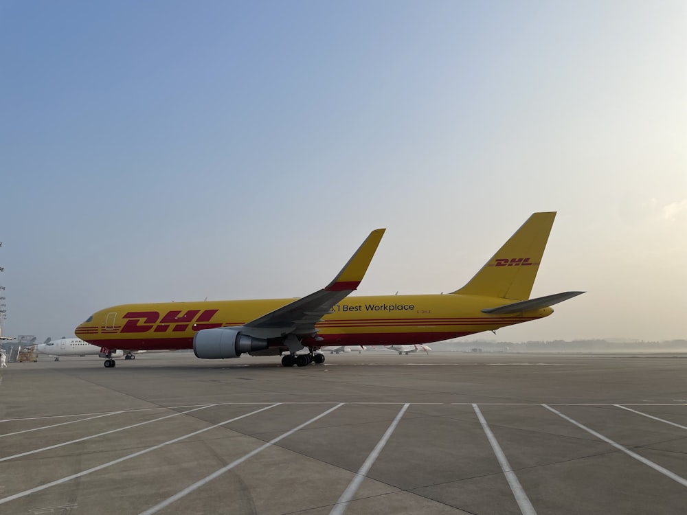 a dhl airplane sitting on the tarmac at an airport