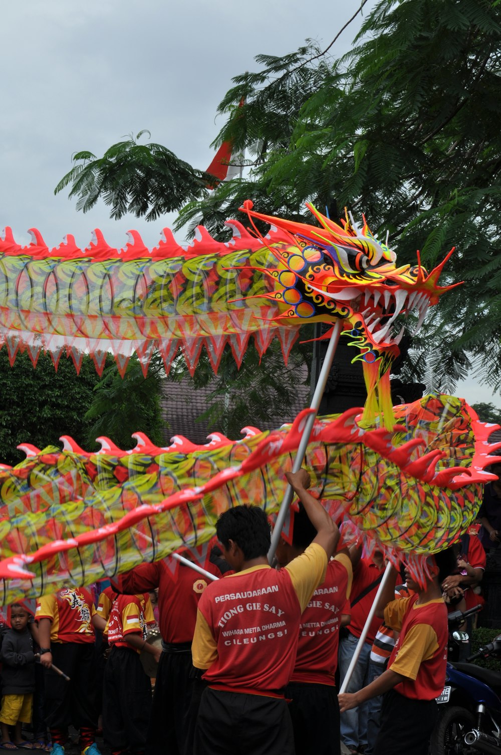 a group of people standing around a dragon kite