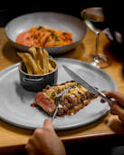 a person cutting a piece of food on a plate