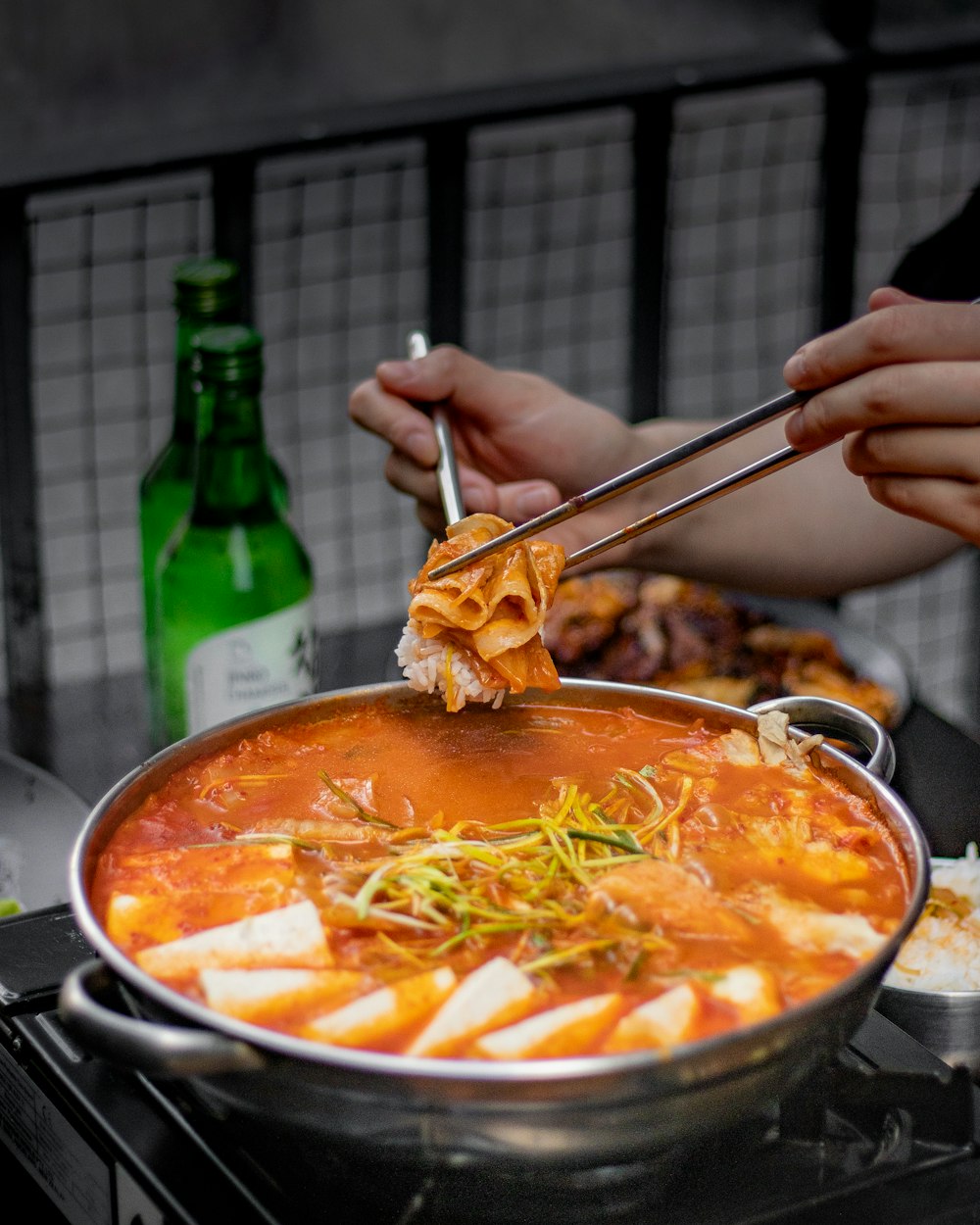 a person holding a spoon over a pot of food