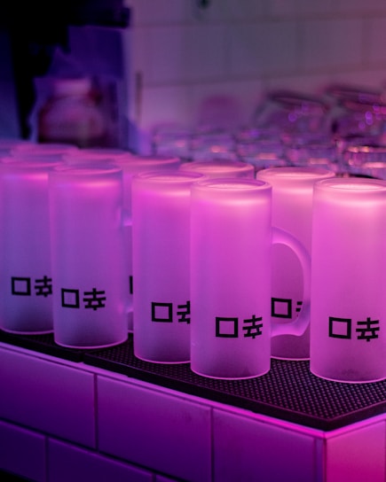 A sleek 3D mug with a custom design glowing softly, surrounded by floating keyrings and caps in a playful arrangement.