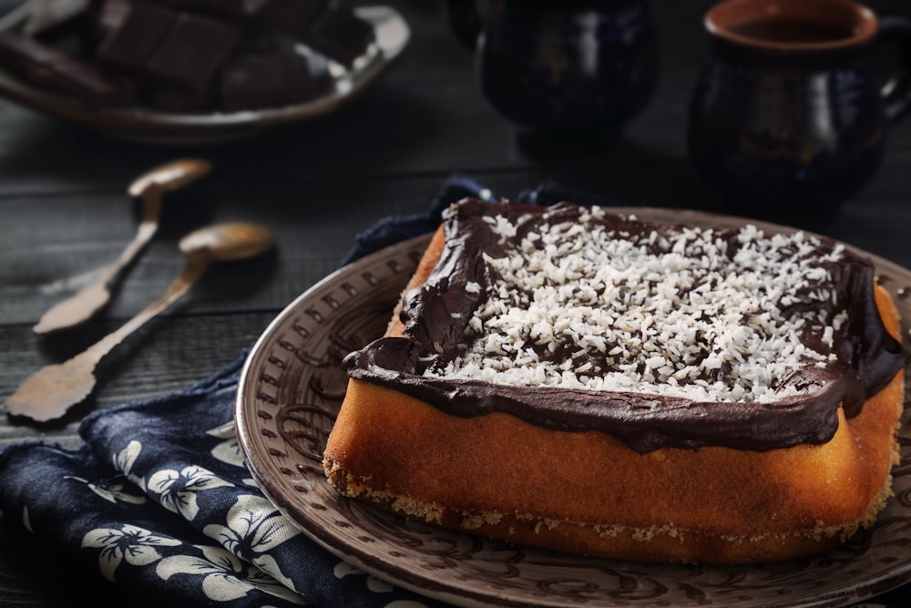 a cake with chocolate frosting and coconut on a plate