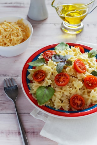 A colorful bowl of penne pasta tossed with cherry tomatoes, basil, and olive oil