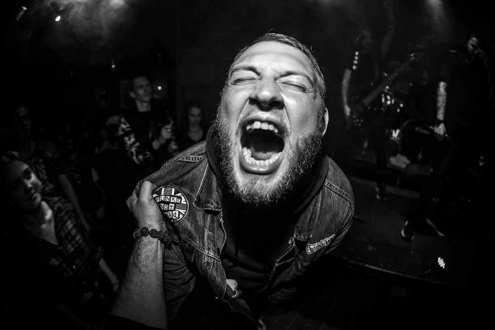 a man with his mouth open in front of a crowd