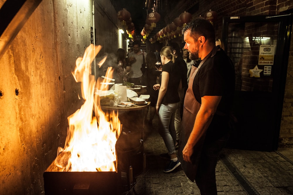 a group of people standing around a fire pit