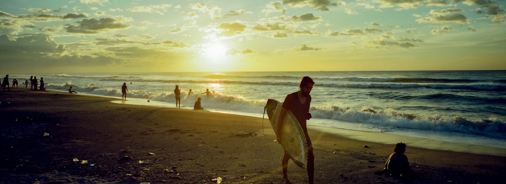 a person standing on a beach holding a surfboard