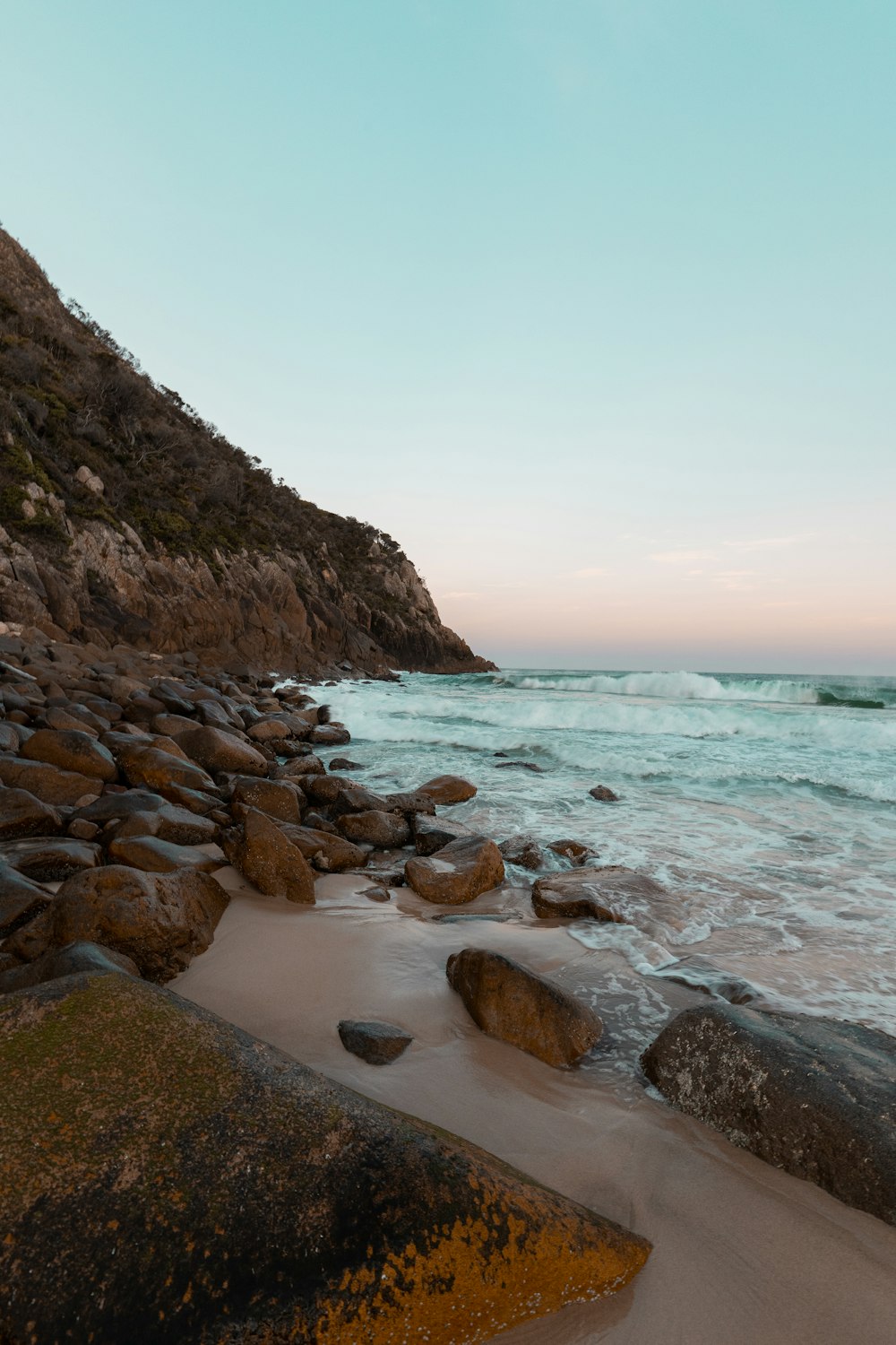 a rocky beach next to a body of water