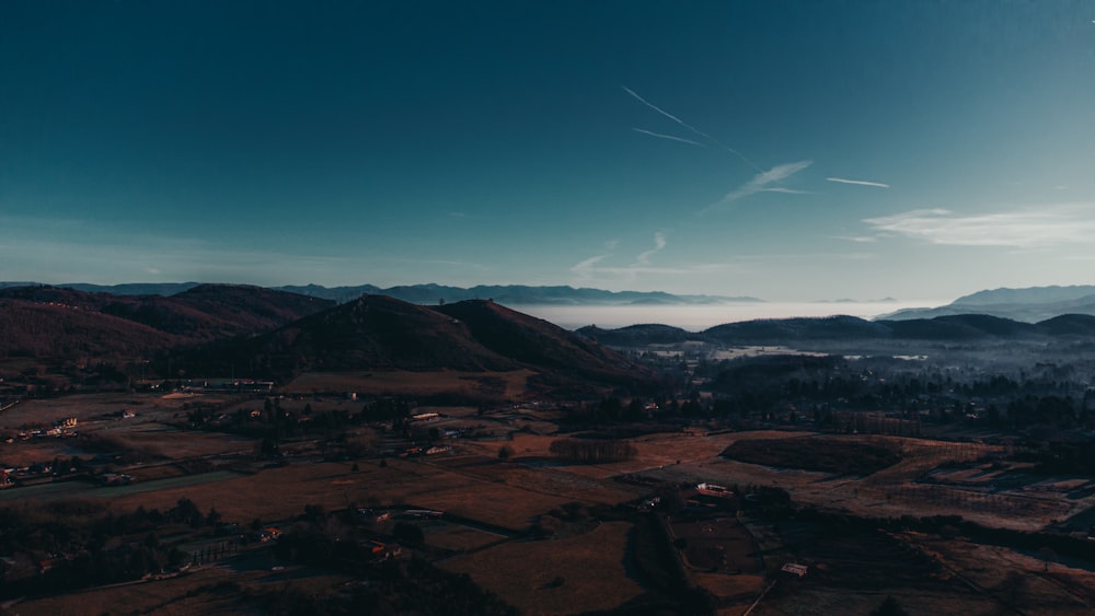 an aerial view of a valley with mountains in the background