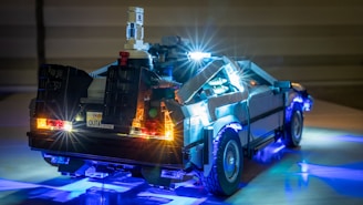 A highly detailed LEGO model of a futuristic car with illuminated lights, capturing an iconic design. The model displays intricate details, such as the glowing rear lights and unique features on the car's structure.