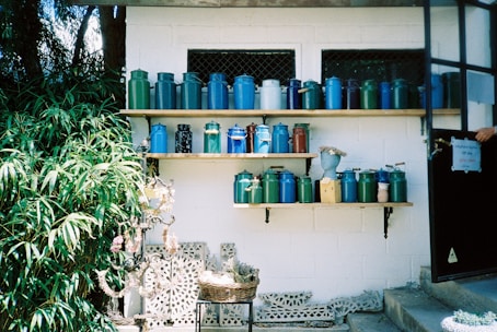 Assortment of colorful cannabis flower jars displayed on a rustic wooden shelf.