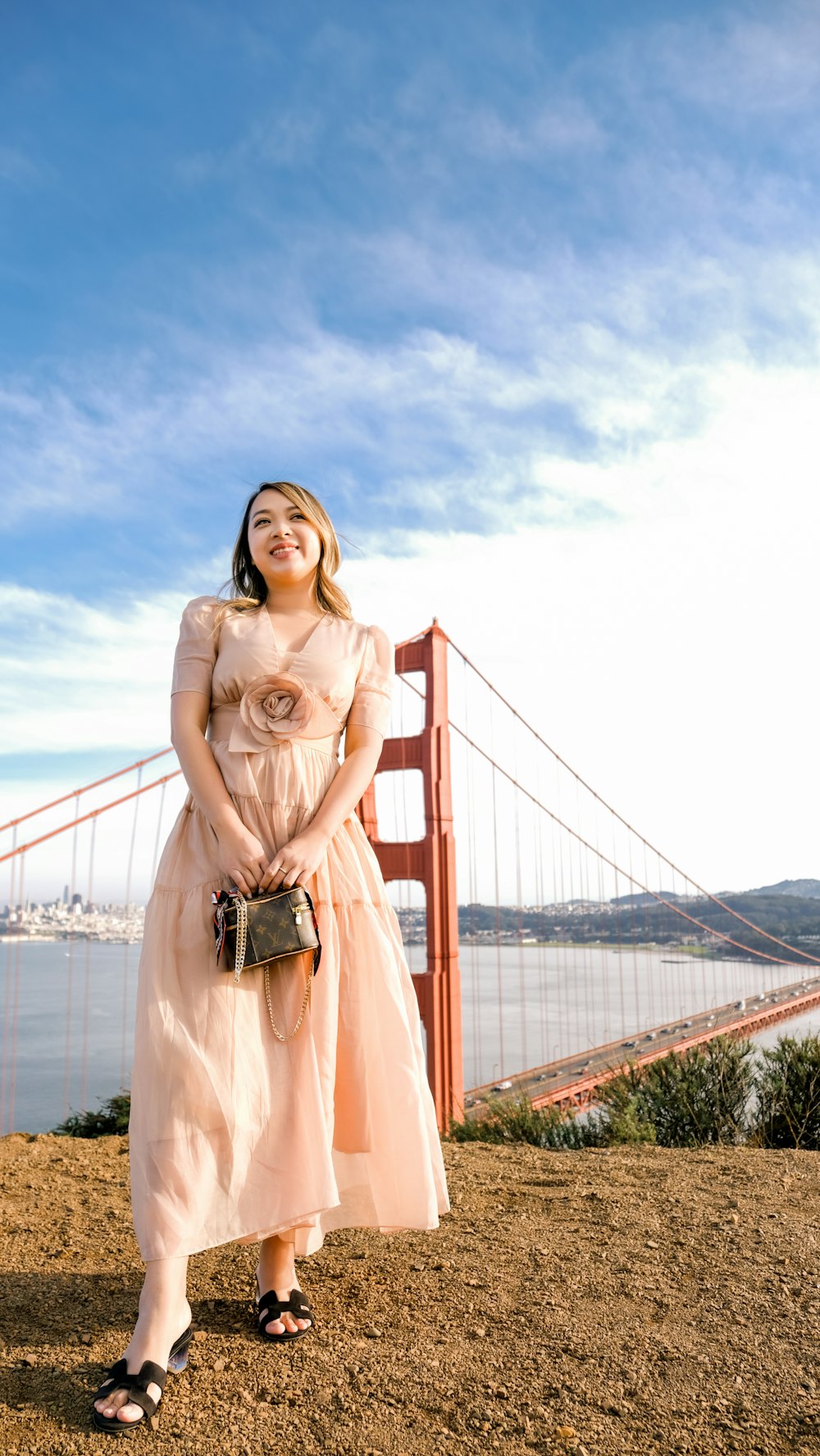 a woman standing in front of the golden gate bridge